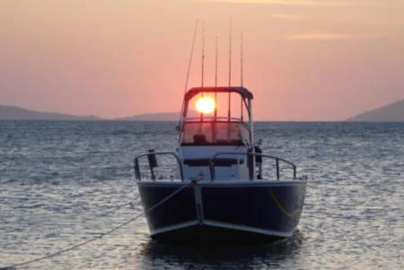 Bow view of a boat silhouetted against the setting sun