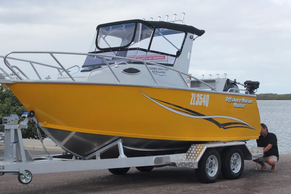 Yellow cabin boat on an alloy tandem-axle trailer