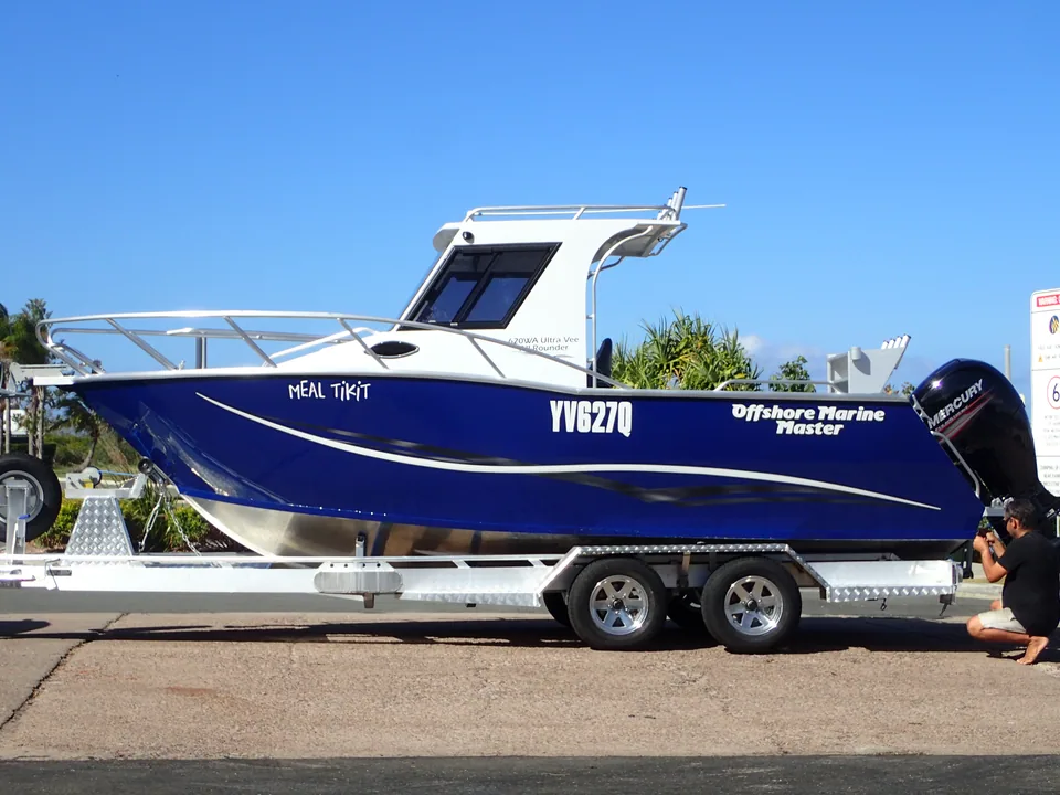 Blue hardtop boat resting on a tandem-axle trailer