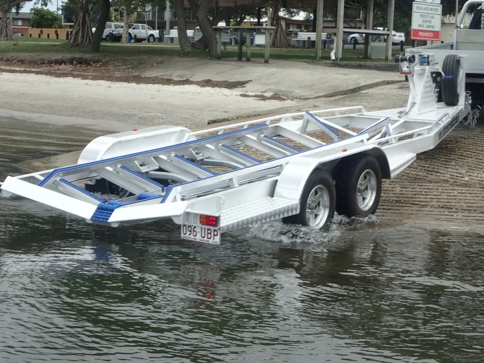 Alloy boat trailer partly submerged at a launch ramp