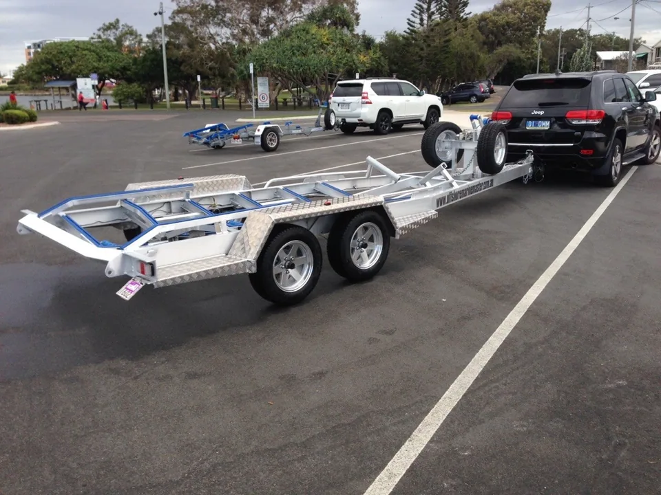 Empty tandem-axle boat trailer attached to a black vehicle