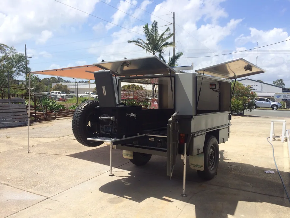 Custom camper trailer with raised side hatches and rear spare wheel