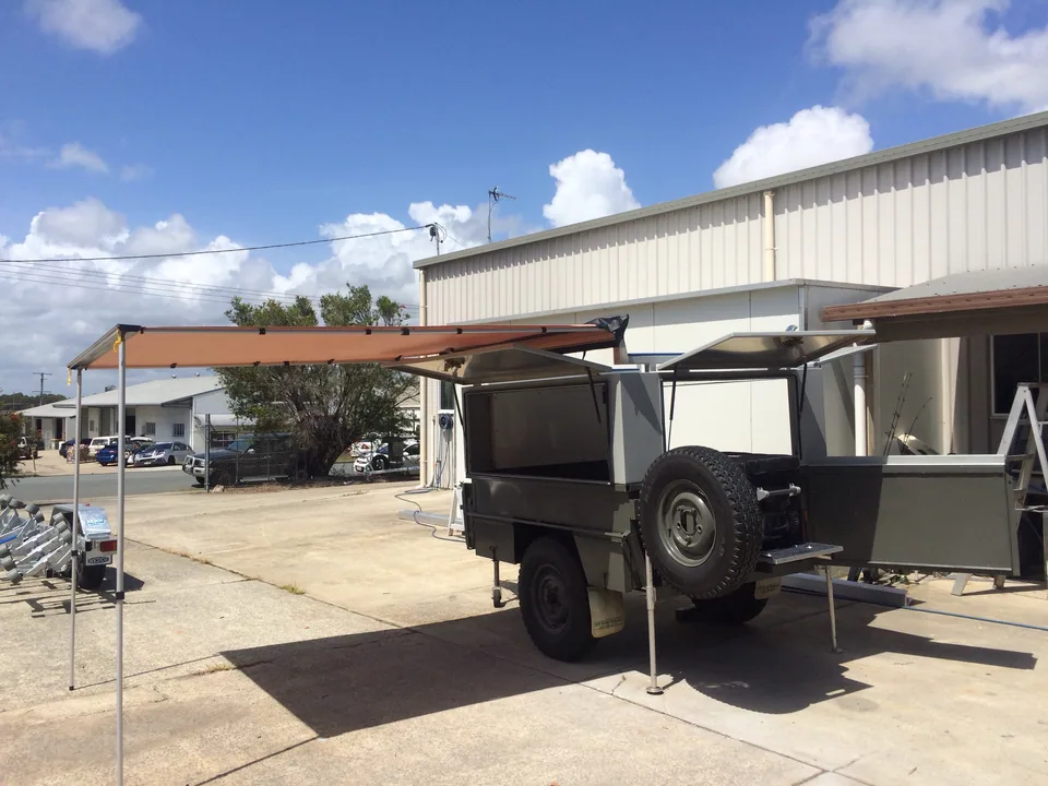 Camper trailer with an extended awning and fold-out side panel