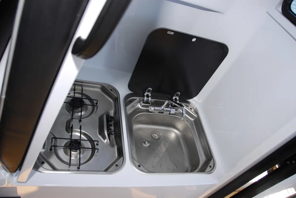 Boat galley with a stainless sink, tap and two-burner cooktop