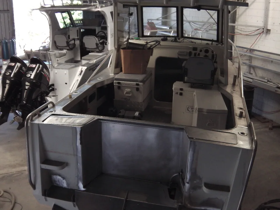 Workshop view of a boat cockpit with metal panels fitted across the transom