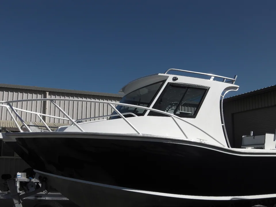 Black boat with a white hardtop cabin and tubular bow rails