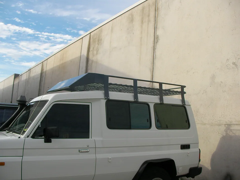 White four-wheel-drive vehicle fitted with a metal roof rack